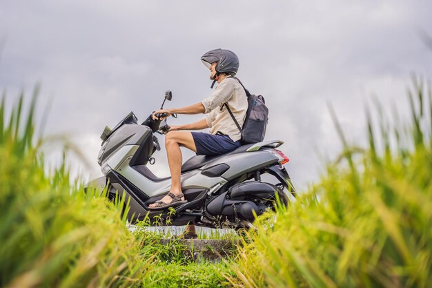 Viaggiatore maschio su una bicicletta tra un campo di riso Viaggi turistici a Bali