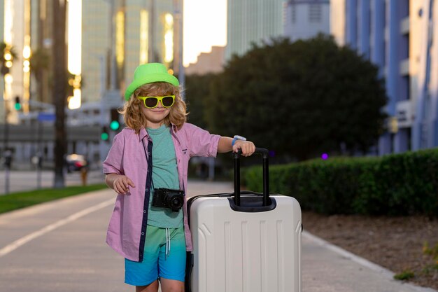 Viaggiatore per bambini con valigia all'aperto Ragazzo turistico che ha un viaggio di vacanza allegro Viaggio per bambini con borsa da viaggio Bambino con valigia sogni di vacanza avventura di viaggio