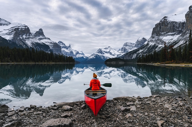 Viaggiatore seduto con pagaia in canoa nel lago Maligne a Spirit Island, il parco nazionale di Jasper, Canada