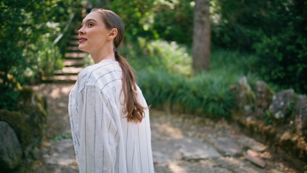 Viaggiatore sereno che cammina nella natura cercando il verde da vicino donna che si rilassa nel parco