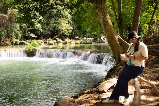 Viaggiatore tailandese donna che posa per scattare foto alle piccole cascate di Chet Sao Noi o al Parco Nazionale di Namtok Chet Sao Noi nel distretto di Muak Lek nella provincia di Saraburi in Thailandia