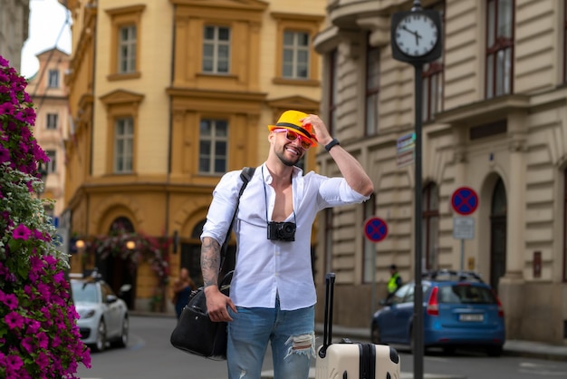 Viaggiatore turista uomo in abiti casuali cappello con valigia turista uomo d'affari in viaggio in Europa c