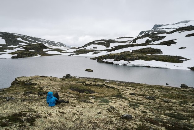 Viaggiatore vicino al lago di montagna in NorvegiaRotta panoramica di Aurlandsfjellet