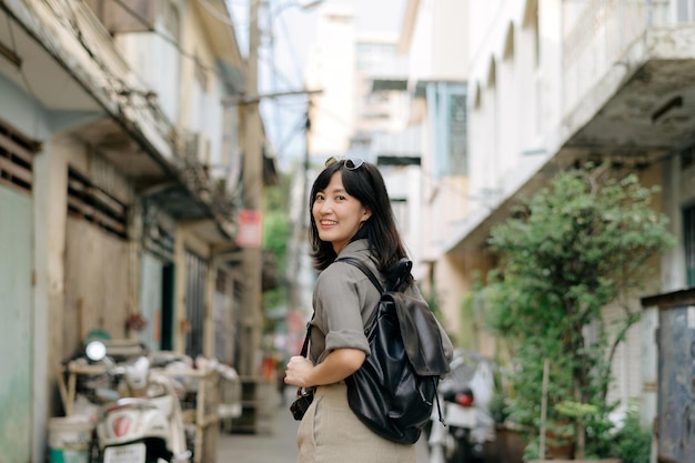 Viaggiatore zaino giovane donna asiatica godendo di strada locale culturale luogo e sorriso Viaggiatore che controlla le strade laterali