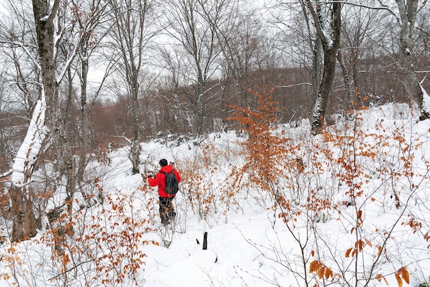 Viaggiatore zaino in spalla nella foresta di montagna invernale