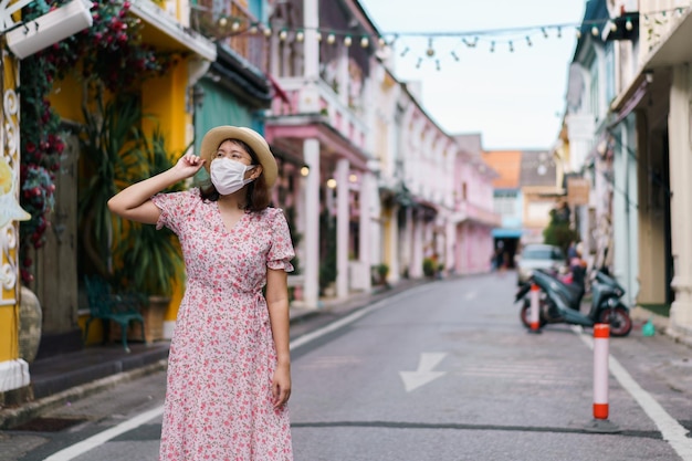 Viaggiatori con maschera che camminano per strada Città vecchia di Phuket con edificio sino all'architettura portoghese nell'area della città vecchia di Phuket Phuket Thailandia Concetto di viaggio e viaggio estivo