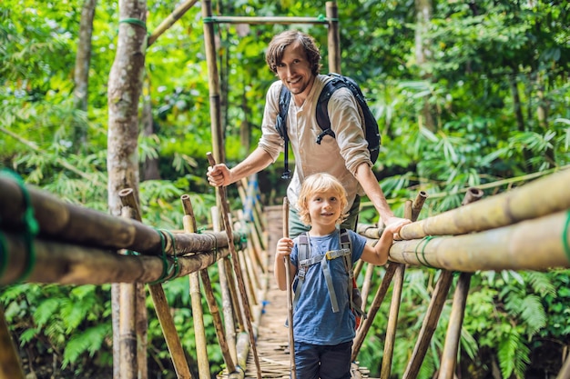 Viaggiatori di padre e figlio sul ponte sospeso a Bali Viaggiare con il concetto di bambini