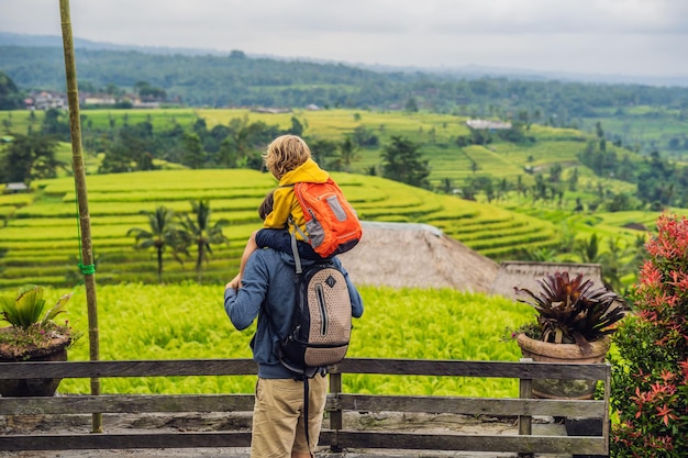 Viaggiatori di papà e figlio sulle bellissime terrazze di riso Jatiluwih sullo sfondo dei famosi vulcani di Bali, Indonesia Viaggiare con il concetto di bambini