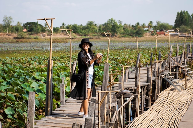 Viaggiatori donne tailandesi persone visitano e posano ritratto per scattare foto al ponte di legno lungo Kae Dam in campagna l'11 gennaio 2019 a Maha Sarakham Thailandia