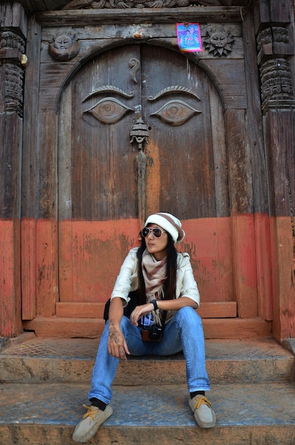 Viaggiatori donne thailandesi viaggi e viaggi visitano l'arte antica occhi della saggezza buddha su antica porta in legno in architettura nepalese e rovina palazzo reale a Basantapur Durbar Square a Kathmandu Nepal