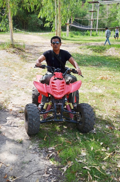 Viaggiatori giovani uomini tailandesi in bicicletta e in sella a motociclette ATV o fuoristrada o quad nella foresta di montagna del resort di attività alla diga di Kaeng Krachan e al Parco Nazionale di Phetchaburi Thailandia