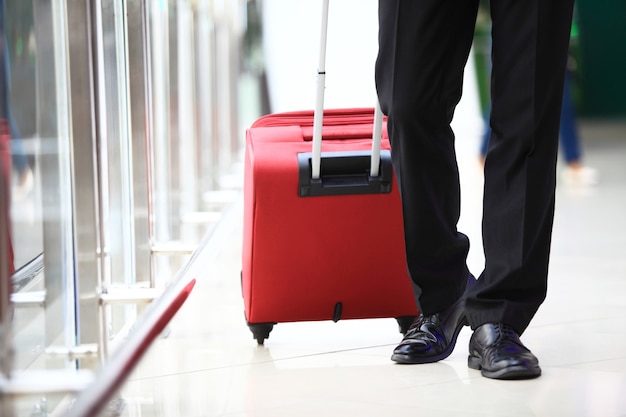 Viaggio di lavoro. Primo piano dell'uomo d'affari che porta la valigia mentre cammina attraverso un ponte di imbarco passeggeri