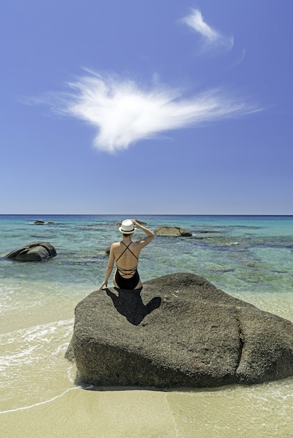 Viaggio di lusso in Sardegna. Donna con un cappello sulla spiaggia a villasimius