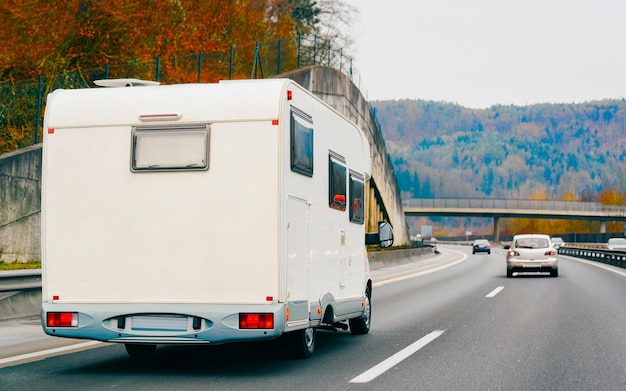 Viaggio di vacanza con Caravan Car su strada. Camper e Summer drive in autostrada. Viaggio di vacanza in camper per la ricreazione. Giro in moto per camper sulla natura. Scenario con veicolo minivan.