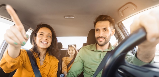 Viaggio in auto in famiglia donna che indica il conducente concentrato