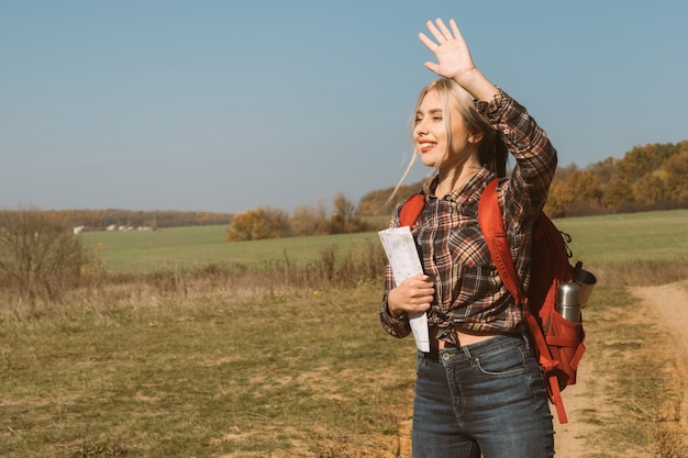 Viaggio in campagna Guida turistica femminile agitando la mano, salutando i viaggiatori Paesaggio autunnale