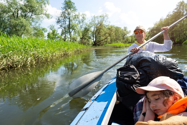 Viaggio in kayak in famiglia Padre e figlia in barca a remi sul fiume un'escursione in acqua un'avventura estiva Turismo ecologico ed estremo Stile di vita attivo e sano