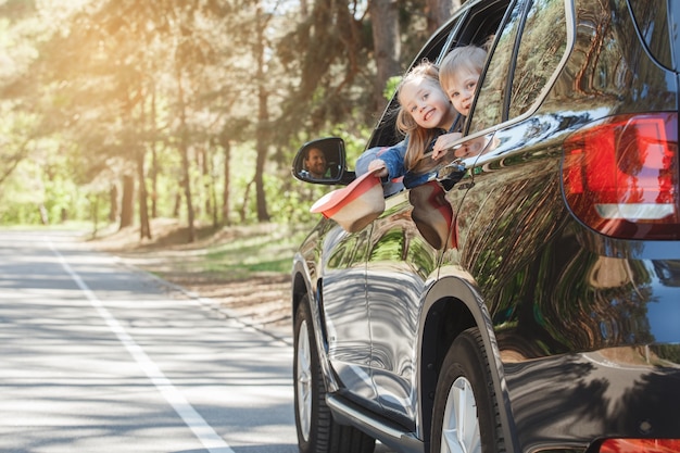 Viaggio in macchina in famiglia, fratello e sorella si affacciano dal finestrino