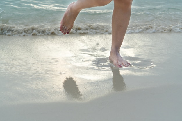 Viaggio in spiaggia - ragazza che cammina sulla spiaggia di sabbia bianca, vacanze e relax