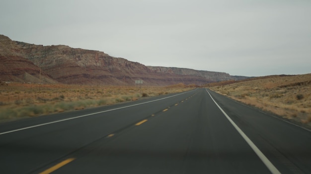 Viaggio su strada al Grand Canyon, Arizona USA, guidando un'auto dallo Utah. Route 89. Viaggio in autostop in America, viaggio locale, atmosfera tranquilla del selvaggio west delle terre indiane. Vista dell'autostrada attraverso il parabrezza dell'auto.