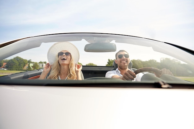 viaggio su strada, viaggio, incontri, coppia e concetto di persone - uomo e donna felici che guidano in auto cabriolet all'aperto