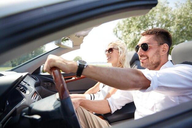 viaggio su strada, viaggio, incontri, coppia e concetto di persone - uomo e donna felici che guidano in auto cabriolet all'aperto