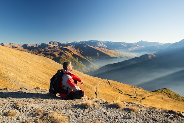 Viandante che riposa sulla cima della montagna