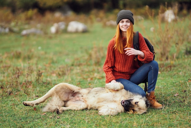 Viandante della donna con lo zaino che cammina il cane nell'avventura della natura