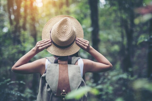 Viandante della giovane donna con lo zaino che guarda la mappa di trekking, facente un escursione concetto.