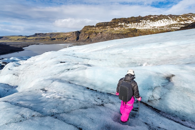 Viandante femminile che cammina sul ghiacciaio a Solheimajokull