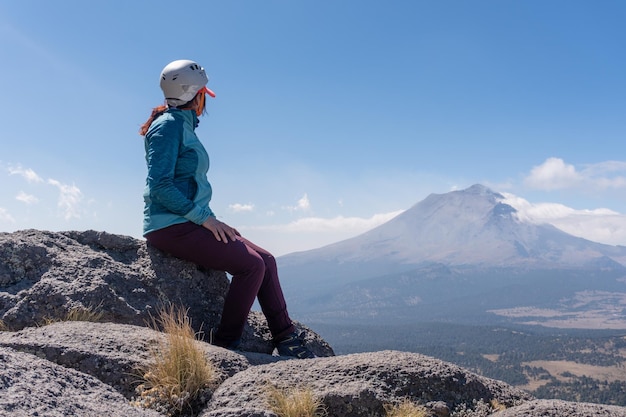 Viandante femminile che esamina vulcano fumante