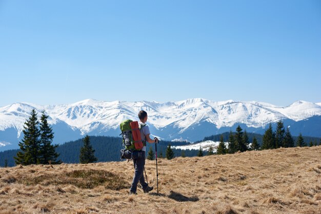 Viandante maschio con lo zaino in montagna