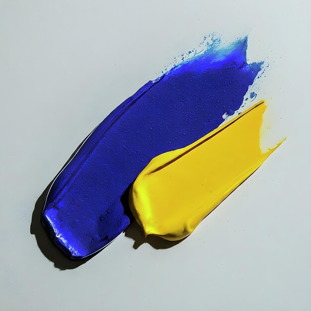 Vibranti tratti di pittura ad olio giallo e blu su uno sfondo bianco