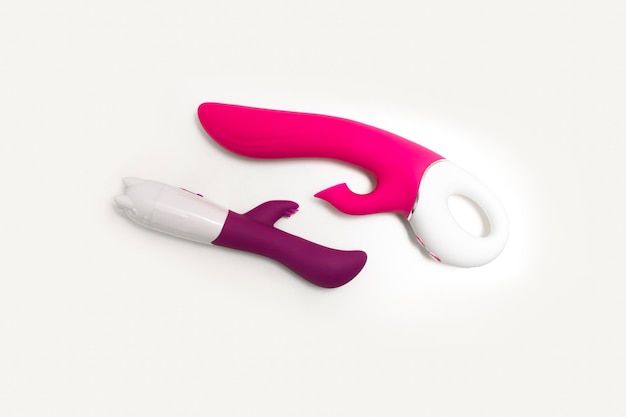 Vibratori rosa e viola (dildo) su sfondo bianco