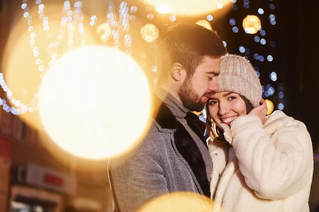 Vicinanza delle persone Felice giovane coppia festeggia il nuovo anno all'aperto sulla strada