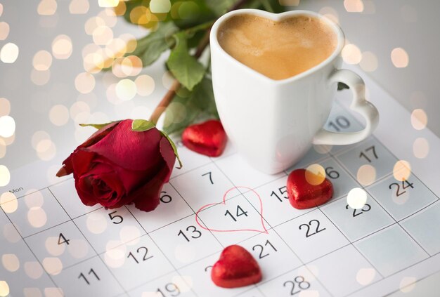 vicino al calendario cuori caffè e rosa rossa