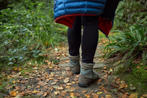 vicino donna che cammina lungo un sentiero nel bosco