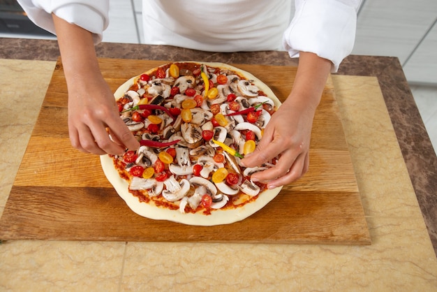 vicino donna che cucina la pizza