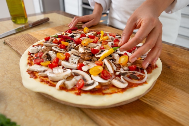 vicino donna che cucina la pizza