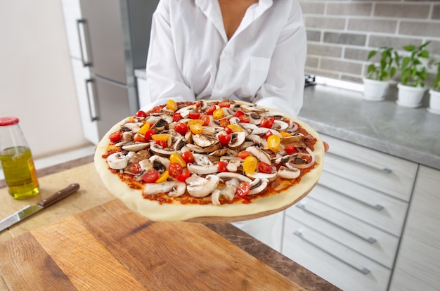 vicino donna che cucina la pizza