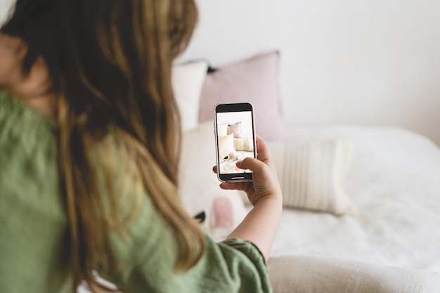 Video blog Una giovane donna sta filmando prodotti per la casa per il suo negozio online con la fotocamera del telefono Gestire un video blog Un vlogger trasmette online utilizzando un telefono Social networkstai a casa e mettiti in quarantena