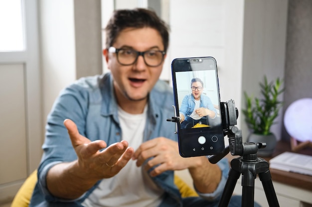 Video blogger che registra i contenuti da canalizzare a casa prima che lo smartphone sia fissato sul treppiede