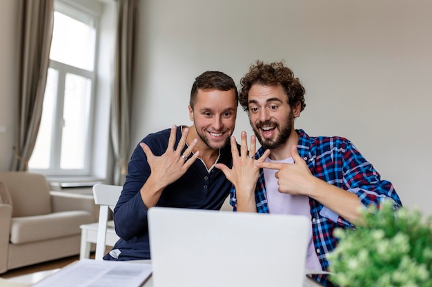 Video di amanti gay che chiamano i loro amici che annunciano il fidanzamento Due giovani amanti gay sorridono allegramente mentre si collegano online dopo essersi fidanzati Uomo gay felice che mostra il suo anello con il suo partner