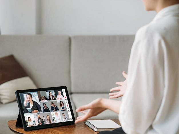 Videoconferenza Affari a distanza Rete di telelavoro Dipendente femminile che discute la strategia online con il team sullo schermo del tablet nell'ufficio di casa con spazio libero