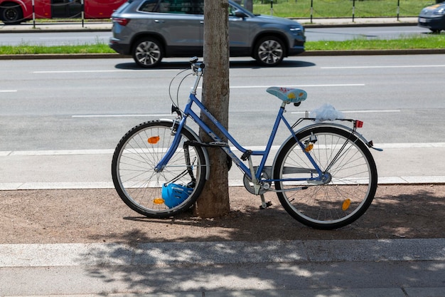 Vienna, Austria, 13 giugno 2023: una bicicletta legata ad un albero vicino alla strada.