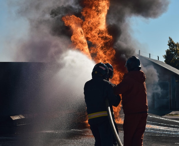 Vigile del fuoco che estingue un incendio di incidente stradale