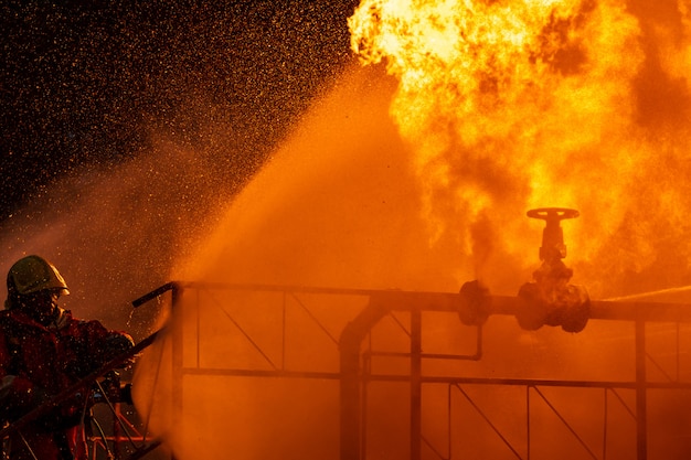 Vigile del fuoco che spruzza la fiamma dalla conduttura