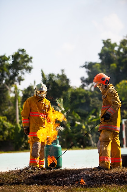 Vigile del fuoco con fuoco e tuta per proteggere il vigile del fuoco per l'addestramento dei vigili del fuoco.