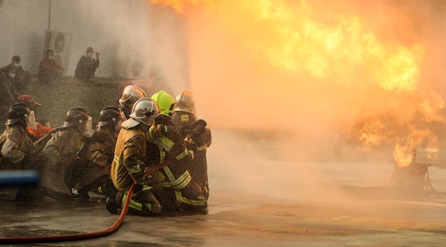 Vigili del fuoco che utilizzano un estintore a nebbia d'acqua Twirl per combattere con la fiamma del fuoco dall'olio per controllare il fuoco non per diffondere Vigile del fuoco e concetto di sicurezza industriale