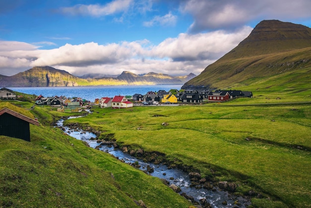 Villaggio di Gjogv sulle Isole Faroe con case colorate e un ruscello